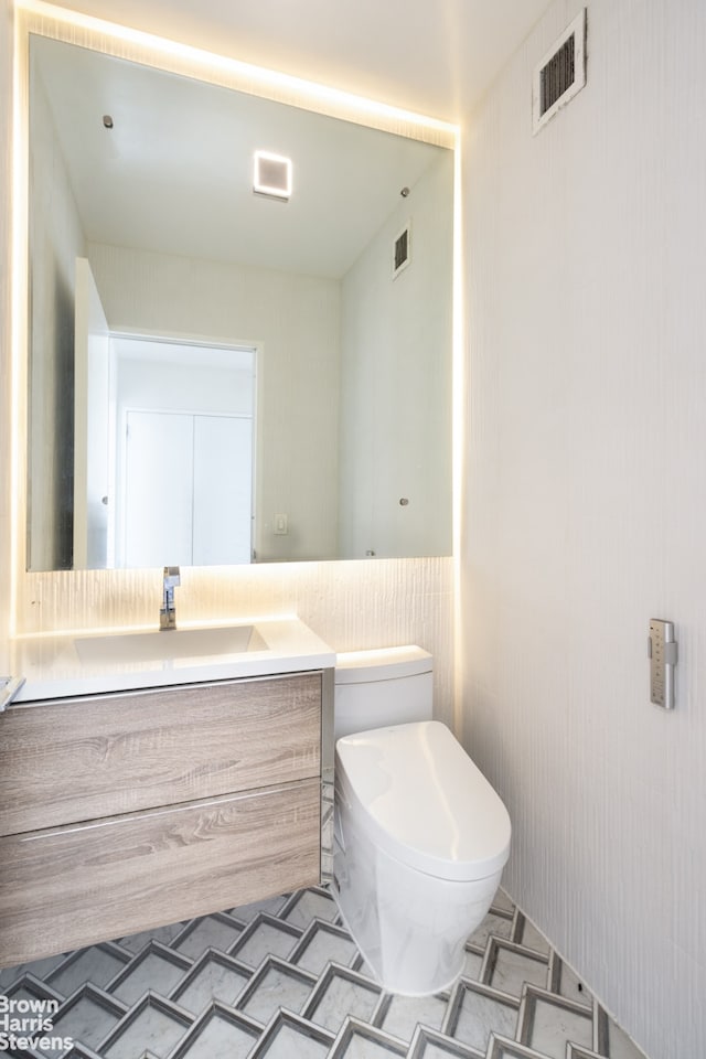 half bathroom with toilet and vanity