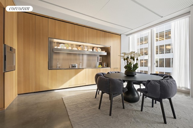 100 E 53rd St Unit 5-A, New York City, NY 10022 - dining area featuring finished concrete flooring and wood walls
