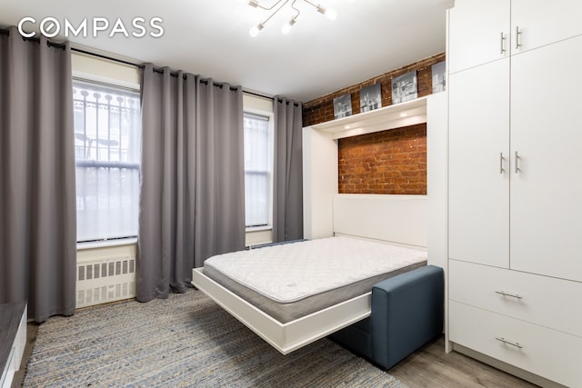 bedroom featuring radiator heating unit and wood finished floors
