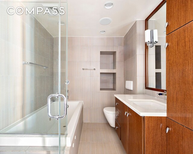 889 Broadway Pha, Pha, New York City, NY 10003 - bathroom with tile walls, tile patterned floors, a stall shower, toilet, and vanity