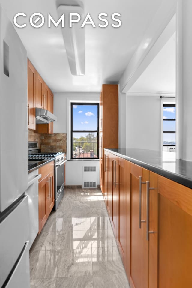 kitchen with stainless steel range with gas cooktop, radiator heating unit, light marble finish floors, fridge, and dishwashing machine