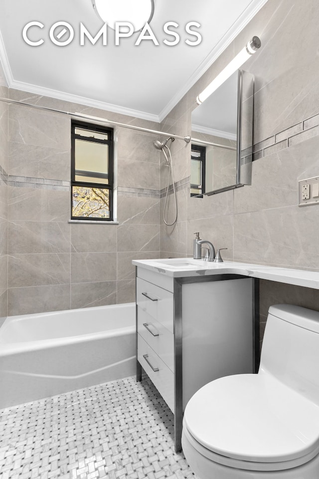 bathroom with ornamental molding, tile walls, toilet, vanity, and tub / shower combination