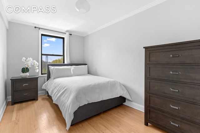 bedroom with ornamental molding, baseboards, and light wood finished floors