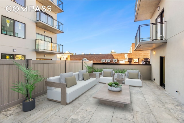 view of patio with a balcony, an outdoor living space, and fence