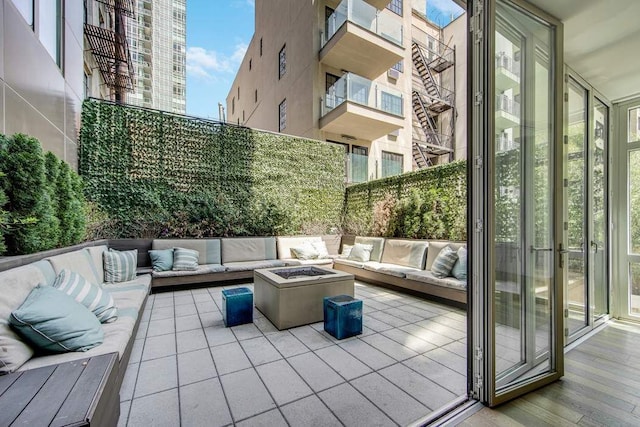 view of patio with an outdoor living space with a fire pit