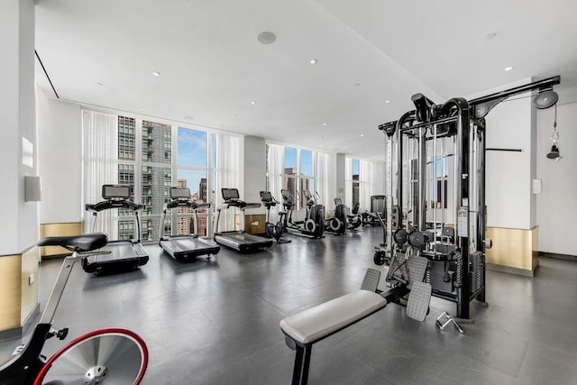 workout area with floor to ceiling windows, a view of city, and recessed lighting