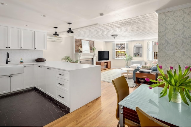 275 Degraw St Unit A, New York City, NY 11231 - kitchen with wallpapered walls, open floor plan, a peninsula, white cabinets, and light countertops