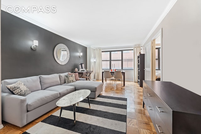 living room featuring crown molding, light wood-style floors, and baseboards