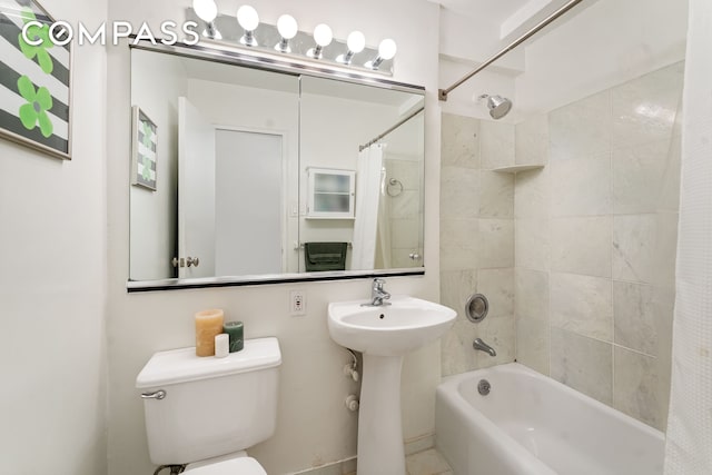 bathroom featuring shower / tub combo with curtain, toilet, and a sink