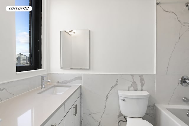 304 E 65th St Unit 26B, New York City, NY 10065 - bathroom featuring tile walls, vanity, toilet, a wainscoted wall, and shower / tub combination