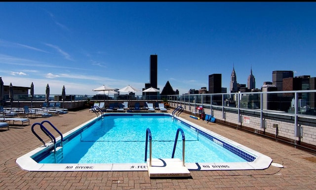 community pool featuring fence and a patio area