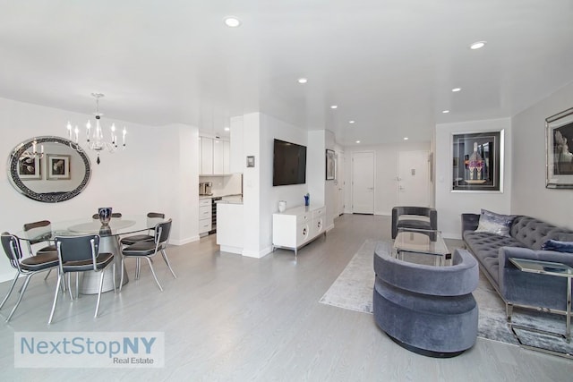 living area featuring a chandelier, wood finished floors, recessed lighting, and baseboards