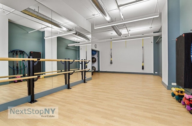 workout area featuring wood finished floors and baseboards