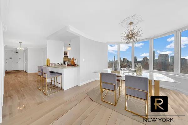330 E 38th St Unit 48-E, New York City, NY 10016 - dining area with a chandelier, light wood-style flooring, and baseboards