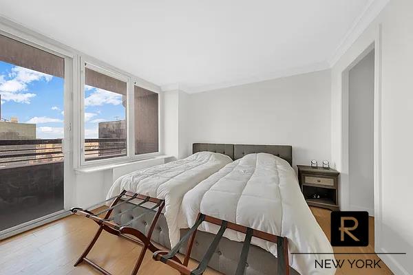 330 E 38th St Unit 48-E, New York City, NY 10016 - bedroom featuring wood finished floors, access to exterior, and ornamental molding