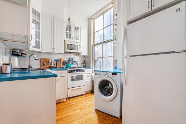 175 E 93rd St Unit 3-B, New York City, NY 10128 - kitchen featuring white appliances, washer / clothes dryer, a sink, and tasteful backsplash