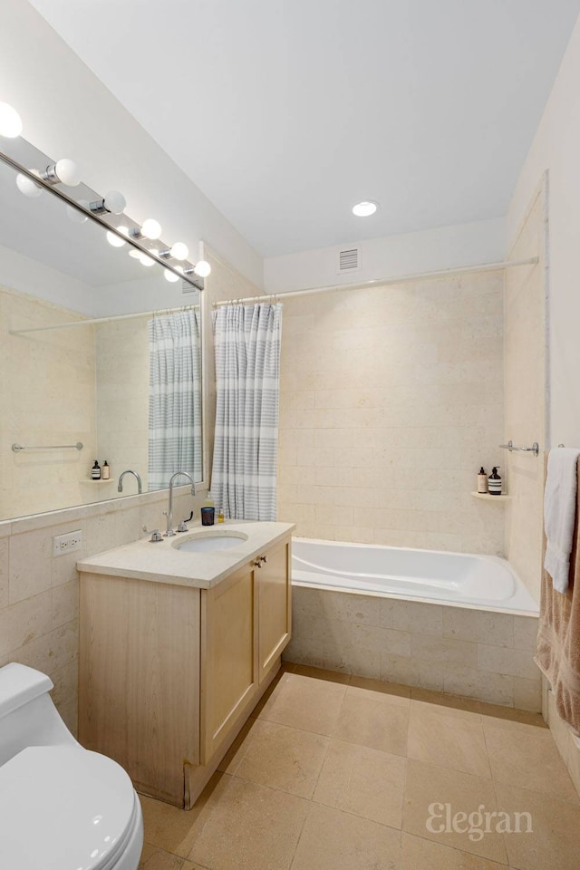 full bath with toilet, vanity, tile walls, and tile patterned floors