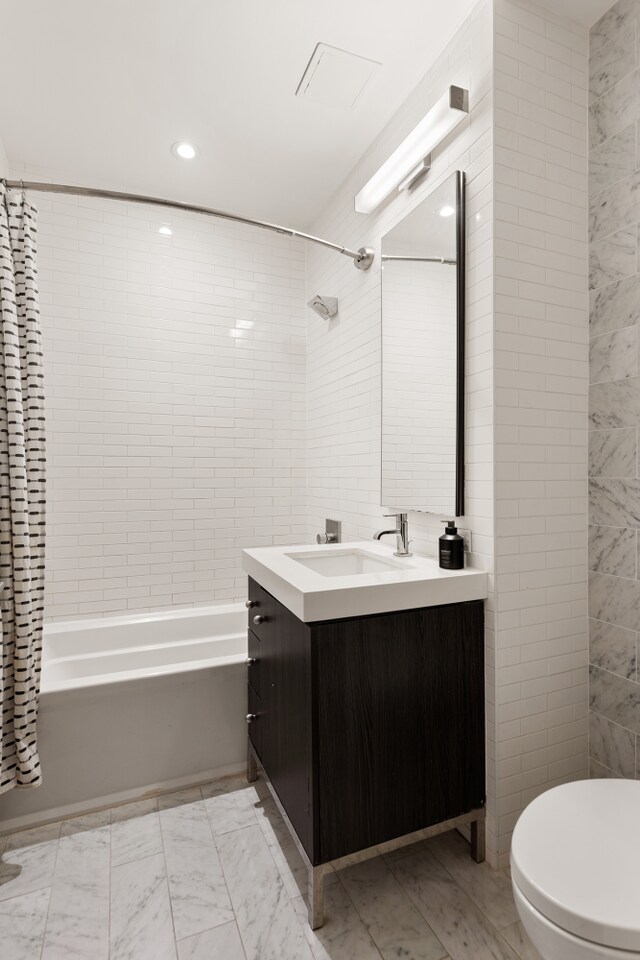 416 W 52nd St Unit 225, New York City, NY 10019 - bathroom with tile walls, vanity, shower / tub combo, toilet, and recessed lighting