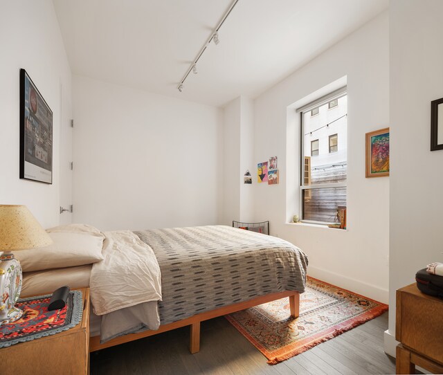 416 W 52nd St Unit 225, New York City, NY 10019 - bedroom with rail lighting, wood finished floors, and baseboards