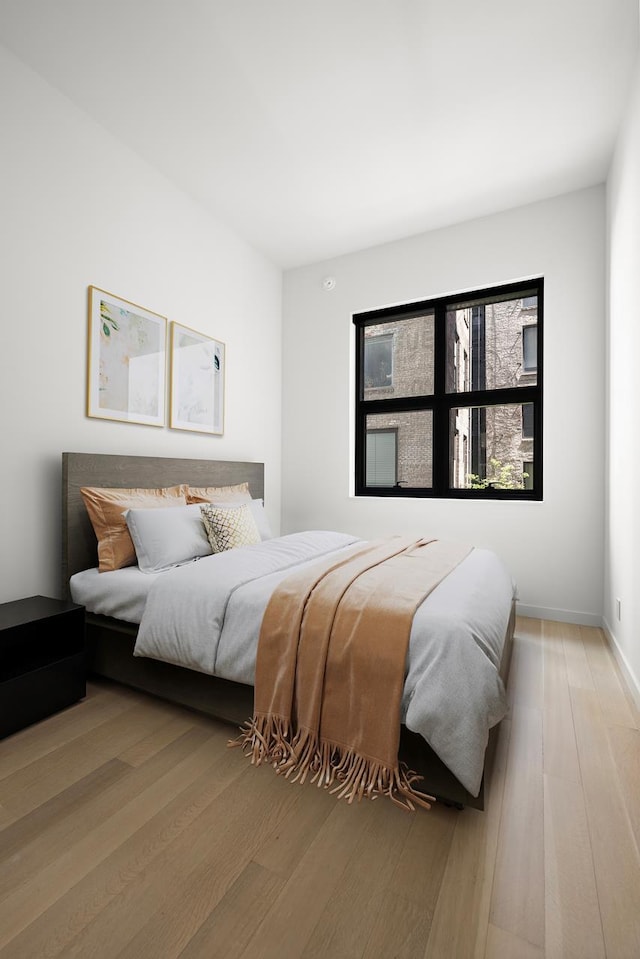 bedroom with light wood-style flooring and baseboards