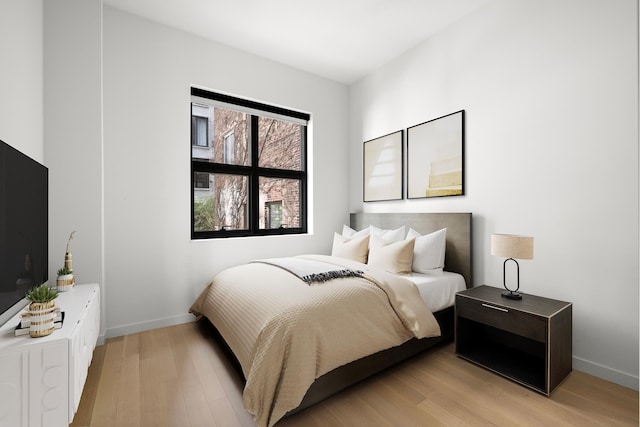 bedroom featuring light wood-style flooring and baseboards
