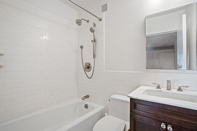 full bath with toilet, vanity, shower / bathtub combination, and tile walls