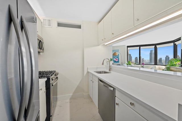 415 E 37th St Unit 31D, New York City, NY 10016 - kitchen featuring stainless steel appliances, a sink, light marble finish floors, baseboards, and a view of skyline