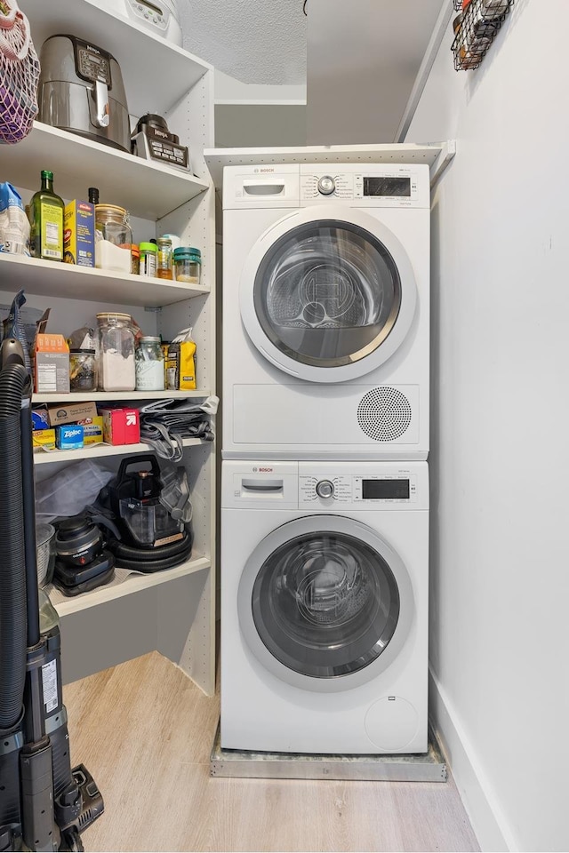 415 E 37th St Unit 31D, New York City, NY 10016 - laundry area with stacked washing machine and dryer and wood finished floors