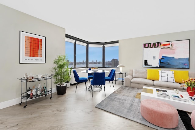 415 E 37th St Unit 31D, New York City, NY 10016 - living room with wood finished floors, floor to ceiling windows, a view of skyline, baseboards, and a water view