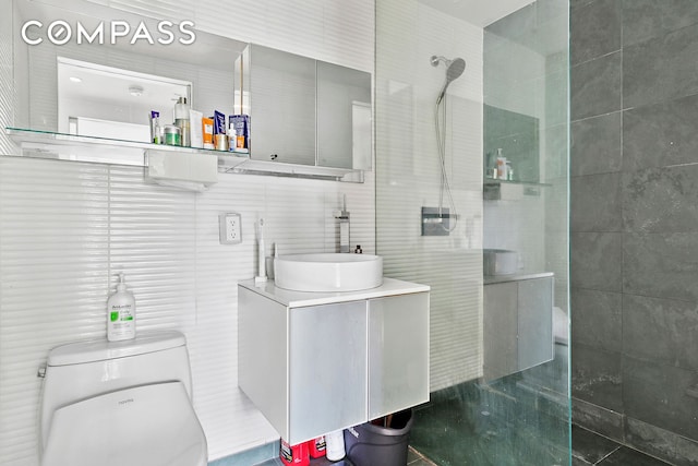 425 E 13th St Unit 5G, New York City, NY 10009 - full bathroom featuring a tile shower, vanity, and tile walls