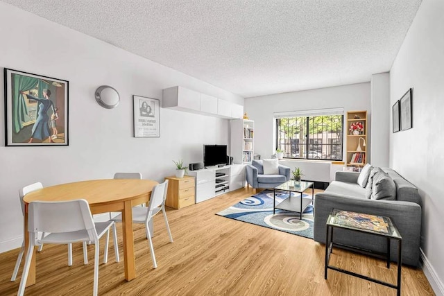 living area featuring light wood-type flooring and a textured ceiling