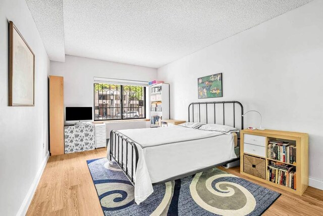 280 Rector Pl Unit 1I, New York City, NY 10280 - bedroom featuring wood finished floors, a textured ceiling, and baseboards