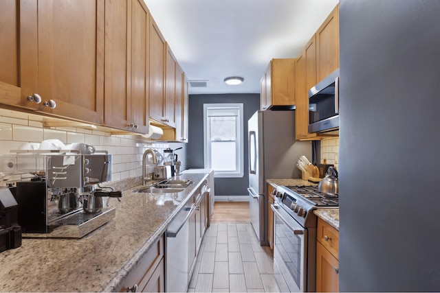 811 Walton Ave Unit F14, New York City, NY 10451 - kitchen with stainless steel appliances, a sink, baseboards, light stone counters, and tasteful backsplash