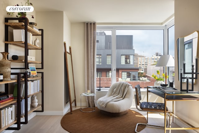 sitting room with wood finished floors, baseboards, and a view of city