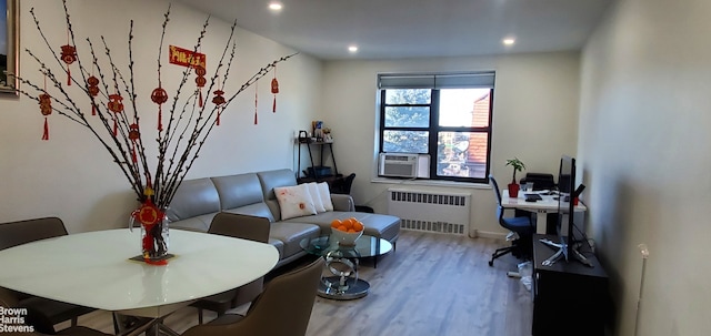 living area featuring radiator, wood finished floors, recessed lighting, and cooling unit