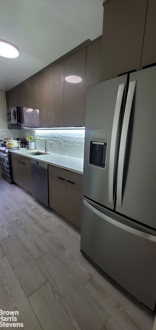 kitchen featuring stainless steel appliances, modern cabinets, a sink, and decorative backsplash