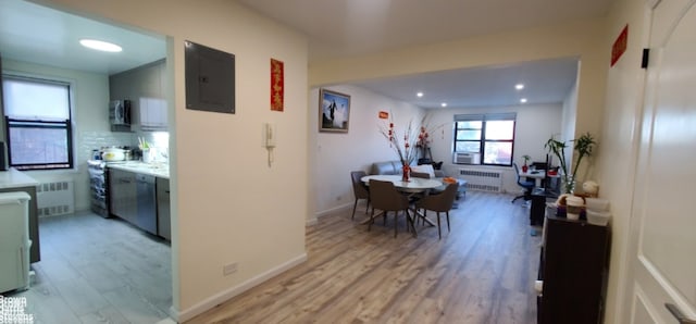 hallway featuring electric panel, radiator heating unit, light wood finished floors, recessed lighting, and baseboards