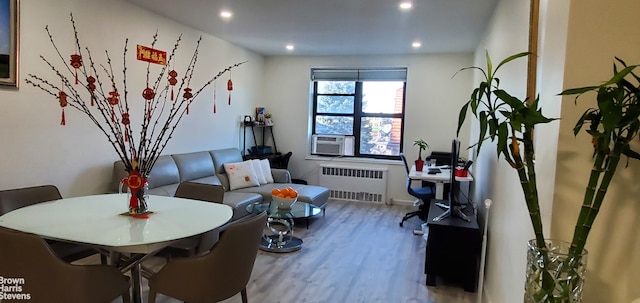 living area featuring radiator heating unit, wood finished floors, recessed lighting, and cooling unit