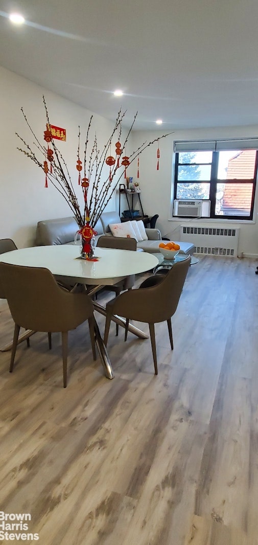 dining space with radiator and light wood-style flooring