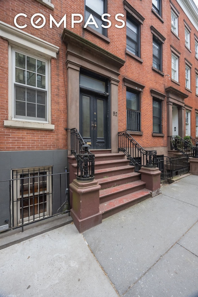 doorway to property featuring french doors and brick siding