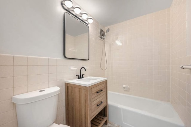 full bath with tile walls, shower / washtub combination, toilet, and vanity