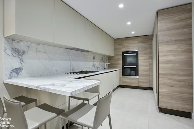 525 E 80th St Unit 7Bc, New York City, NY 10075 - kitchen featuring modern cabinets, a kitchen breakfast bar, gas cooktop, recessed lighting, and a peninsula