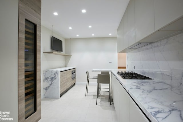 525 E 80th St Unit 7Bc, New York City, NY 10075 - kitchen featuring modern cabinets, recessed lighting, gas stovetop, tasteful backsplash, and light stone counters