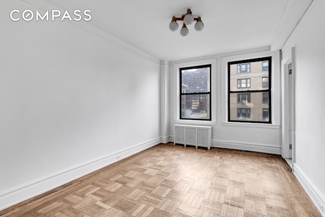 spare room with radiator and baseboards