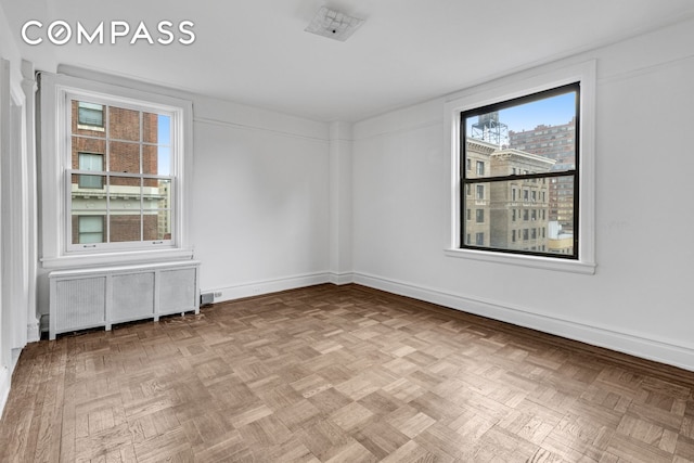 unfurnished room with radiator and baseboards