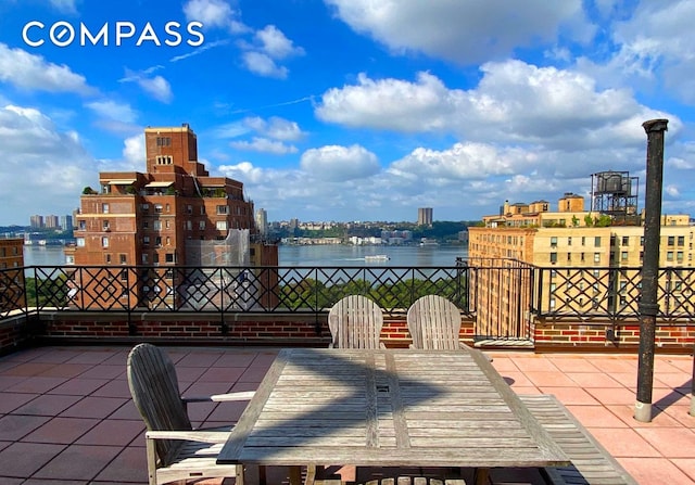 view of patio featuring a water view, a city view, and outdoor dining area