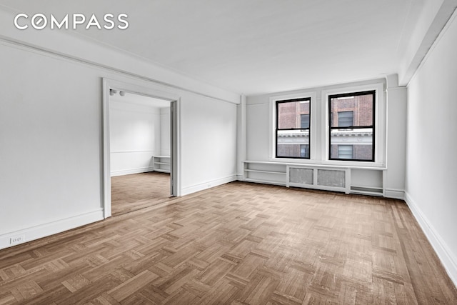 unfurnished room with baseboards