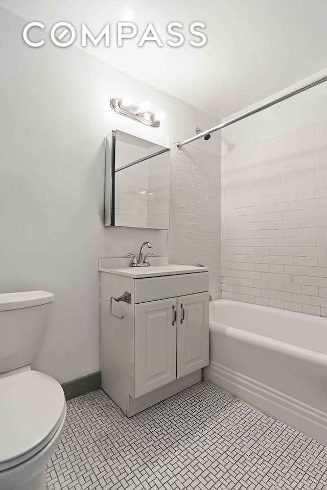 full bath featuring toilet, vanity, shower / washtub combination, baseboards, and tile patterned floors