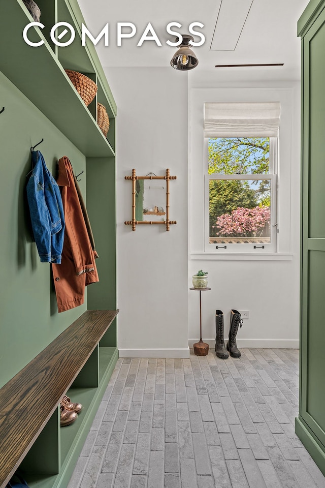 mudroom featuring baseboards and brick patterned flooring