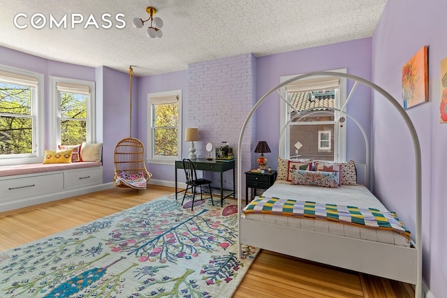bedroom with wood finished floors and a textured ceiling